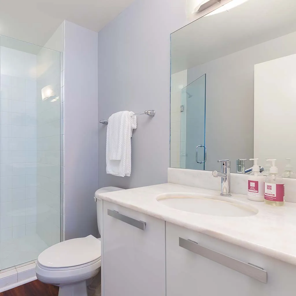 White bathroom with glass shower, spotless and fresh